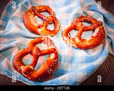 Drei leckere bayerische Brezeln am Tisch, Draufsicht, Nahaufnahme Stockfoto