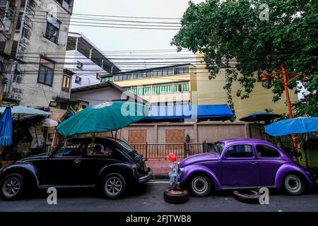Zwei alte VW Käfer Autos sind in einer Straße in der Chinatown Gegend von Bangkok, Thailand geparkt Stockfoto