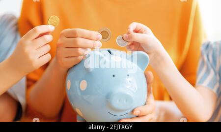 Frau und Kinder mit einem Sparschwein. Konzept der Berechnung der Ausgaben, Verwaltung des Familienbudgets. Stockfoto