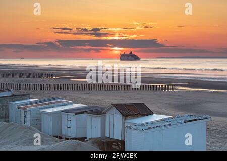 Frankreich, Pas de Calais, Cote d'Opale, Sangatte Bleriot Plage, Fähre, die die Bootverbindung von Calais nach Dover bei Sonnenuntergang und Strandhütten verbindet Stockfoto