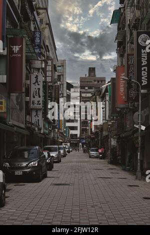 TAIPEI, TAIWAN - 22. Jul 2019: Straße in der Stadt Taipei, Taiwan. Ruhige Straße mit geparkten Autos und mehreren Schildern. Stockfoto