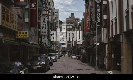 TAIPEI, TAIWAN - 22. Jul 2019: Straße in der Stadt Taipei, Taiwan. Ruhige Straße mit geparkten Autos und mehreren Schildern. Stockfoto