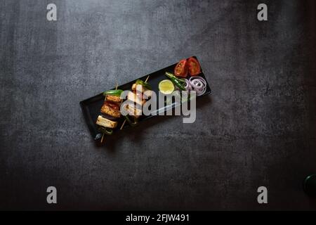 Paneer oder Quark Tikka ist ein indisches Gericht aus Brocken Paneer mariniert mit Gewürzen zusammen mit Gemüse und gegrillt in einem Tandoor. Stockfoto