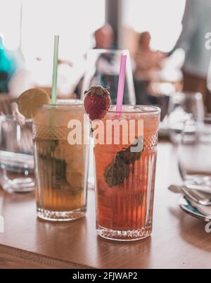 Zwei Mojito-Cocktails mit gereiftem Rum, Minze und verschiedenen Früchten. Eine Erdbeere und die andere Passionsfrucht Stockfoto