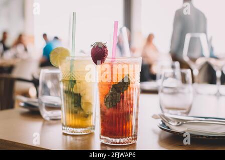 Zwei Mojito-Cocktails mit gereiftem Rum, Minze und verschiedenen Früchten. Eine Erdbeere und die andere Passionsfrucht Stockfoto