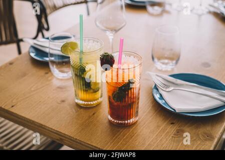 Zwei Mojito-Cocktails mit gereiftem Rum, Minze und verschiedenen Früchten. Eine Erdbeere und die andere Passionsfrucht Stockfoto