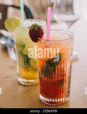 Zwei Mojito-Cocktails mit gereiftem Rum, Minze und verschiedenen Früchten. Eine Erdbeere und die andere Passionsfrucht Stockfoto