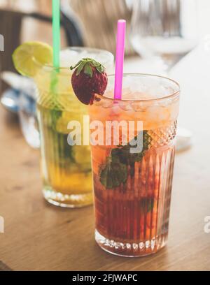 Zwei Mojito-Cocktails mit gereiftem Rum, Minze und verschiedenen Früchten. Eine Erdbeere und die andere Passionsfrucht Stockfoto