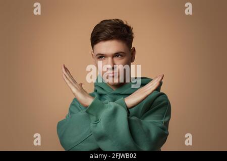 Junger gutaussehender Kerl im Sweatshirt mit Stop-Geste Stockfoto