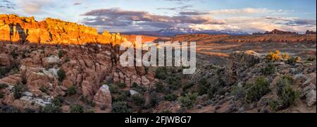 Ein Panoramablick auf den Feuerofen, das Salt Valley und die La Sal Mountains kurz vor Sonnenuntergang im Arches National Park in Moab, Utah. Stockfoto