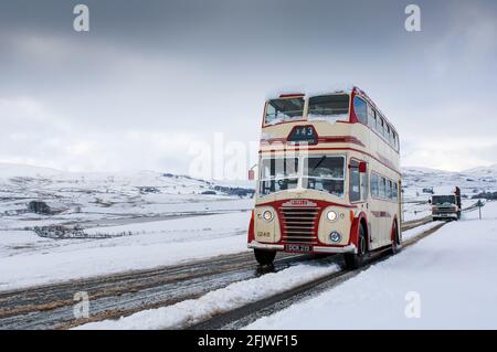 Klassischer Doppeldecker-Ribble-Bus auf einer verschneiten Straße in Cumbria bei Ravenstonedale auf der A684, Großbritannien. Stockfoto