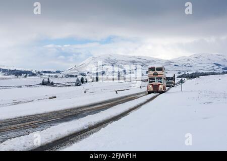 Klassischer Doppeldecker-Ribble-Bus auf einer verschneiten Straße in Cumbria bei Ravenstonedale auf der A684, Großbritannien. Stockfoto