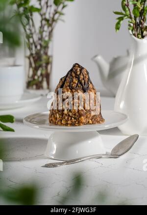 Ameisenbartkuchen mit Kondensmilch, gegossen mit Schokolade auf einem weißen Ständer mit hartem Licht Stockfoto