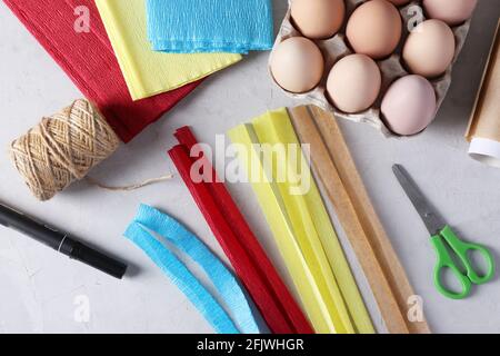 Wir dekorieren Eier für Ostern mit farbigem Papier und Pergament in Form von Kaninchen. Streifen für Kaninchenohren aus farbigem Papier ausschneiden. Schritt 2. Stockfoto