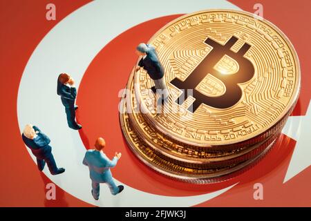 Business Meeting über die Investitionsentscheidung für das Bitcoin-Konzept: Miniatur-Geschäftsmänner, die in der Nähe des Stapels aus glänzendem goldenem Bitcoin stehen Stockfoto