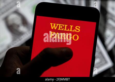 China. April 2021. In dieser Abbildung ist das Banklogo des amerikanischen multinationalen Finanzdienstleisters Wells Fargo auf einem Smartphone mit US-Dollar (USD) im Hintergrund zu sehen. (Foto von Budrul Chukrut/SOPA Images/Sipa USA) Quelle: SIPA USA/Alamy Live News Stockfoto
