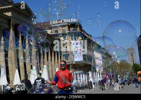 Stuttgart, Deutschland. April 2021. Ein Straßenkünstler produziert überdimensionale Seifenblasen auf dem Schlossplatz vor der Kulisse des Königsbaus. Quelle: Bernd Weißbrod/dpa/Alamy Live News Stockfoto