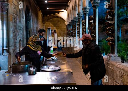Esp. April 2021. Ein Freiwilliger serviert am 23. April 2021 in der Sant Anna Kirche in Barcelona, Spanien, kostenlose Iftar-warme Mahlzeiten in der Wohltätigkeitsküche während des muslimischen Fastenmonats Ramadan. Die Wirtschaftskrise, die durch die Pandemie ausgelöst wurde, hat dazu geführt, dass die Nachfrage nach kostenlosen Mahlzeiten aus den ärmsten und benachteiligten Sektoren der Gesellschaft in Katalonien und Spanien stark angestiegen ist (Foto: Davide Bonaldo/Sipa USA) Quelle: SIPA USA/Alamy Live News Stockfoto