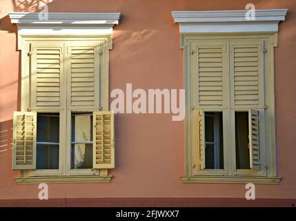 Neoklassizistische Hausfassade mit venezianischem Stuckputz und ockerfarbenen Fensterläden aus Holz in Nafplio, Argolis Peloponnes, Griechenland. Stockfoto