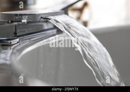 Führen Sie das Wasser aus dem Wasserhahn eines breiten Badezimmers in einen aus Heißer Whirlpool Stockfoto