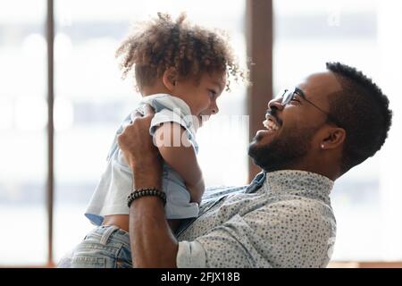 Glücklicher Vater hält Kind in den Armen, umarmt Kleinkind Junge Stockfoto