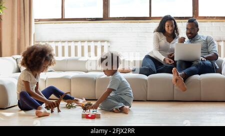 Nette Vorschulkinder, die mit Spielzeug-Dinosauriern auf dem Heizboden spielen Stockfoto