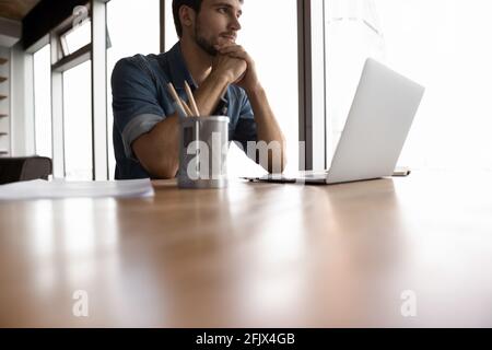 Pensive kaukasischen Mann arbeiten auf Laptop denken Stockfoto