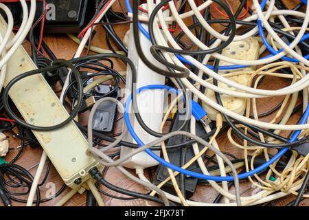 Auf dem Boden liegt ein verworrenes Gewirr unnötiger Drähte. Stockfoto