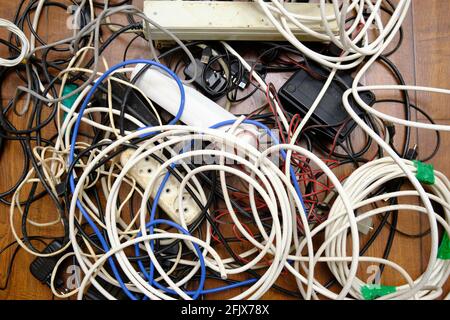 Auf dem Boden liegt ein verworrenes Gewirr unnötiger Drähte. Stockfoto