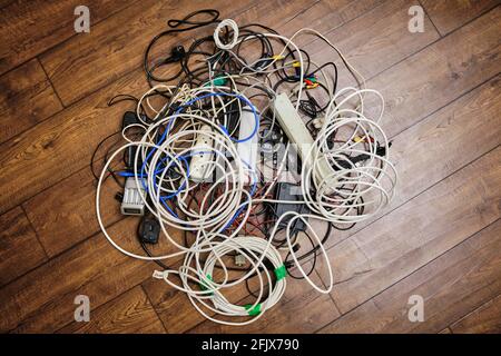 Auf dem Boden liegt ein verworrenes Gewirr unnötiger Drähte. Stockfoto