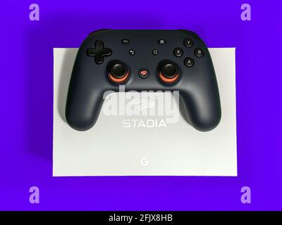 Seattle, WA / USA - ca. November 2019: Nahaufnahme eines Google Stadia Gaming Controllers, der auf einer weißen Box vor einem farbenfrohen Hintergrund ruht Stockfoto