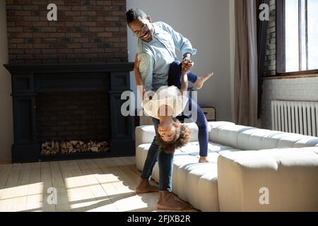 Glücklicher Vater und lehrten aufgeregt kleine Tochter zu tanzen Stockfoto