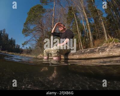 Wanderer macht eine Pause mit den Füßen im Wasser Stockfoto