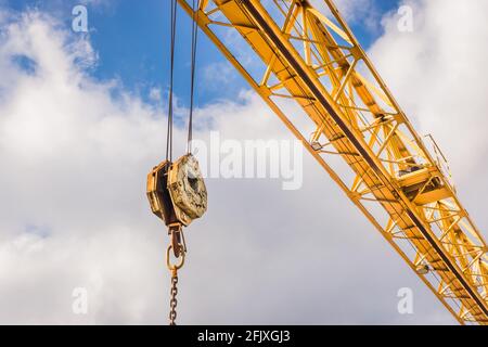 Hebezeug Industriemechanismus mit Haken und Kette auf einem Hintergrund des blauen Himmels mit Wolken, Nahaufnahme. Stockfoto