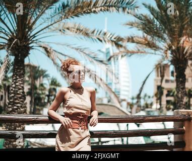 Glückliche schöne touristische Frau im Sommerkleid genießen Urlaub in Dubai in den Vereinigten Arabischen Emiraten Stockfoto