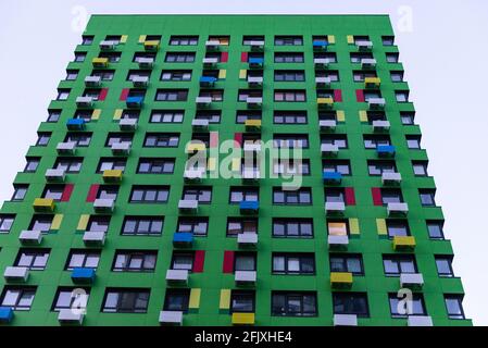 Grüne Fassade eines mehrstöckigen Gebäudes. Mehrfarbige Boxen für die Klimaanlage. Stockfoto