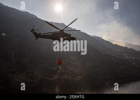 Killarney National Park, Irland - 26. April. 2021: Irish Air Corp Hubschrauber sammeln Wasser, um Feuer im Killarney Nationalpark zu löschen Stockfoto