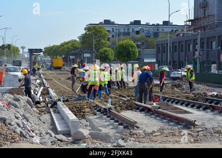 Chinesische Arbeiter, die in Jiaxing eine neue Bahntransitlinie bauen, möglicherweise Wanderarbeitnehmer, einschließlich Frauen, die die Arbeit verrichten. Stockfoto