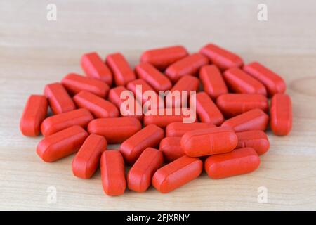 Rote Folie beschichtete Tabletten Multi Vitamine und Mineralien, Anti-Stress-Formel auf Holz, Hintergrund Stockfoto