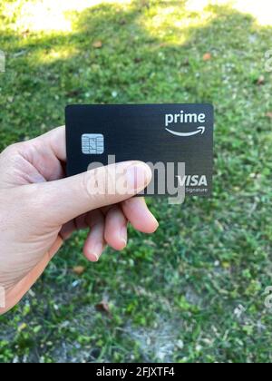 Eine Frau hält eine Amazon Prime Rewards Visa Signature Card in der Hand. Stockfoto
