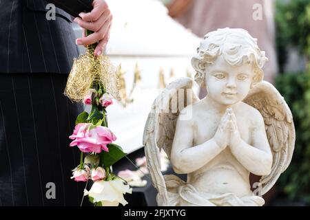 Trauer um Frau auf der Trauerfeier am Sarg oder Sarg mit rosa rose Stockfoto