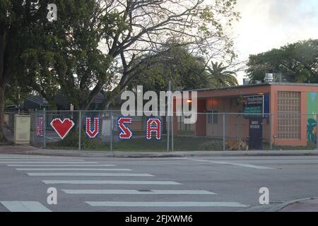 Die Meadowlane Elementary School in Hialeah, Florida, zeigt auf einem Zaun ein Schild „Wir lieben die USA“ mit Patriotismus. Stockfoto