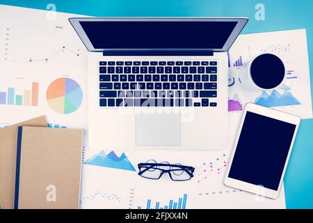 Laptop-Computer und Dokumente berichten über die Finanzstatistik mit Grafik und Grafik und Brille und Tablet, Finanzen und Investitionen, digitales Marketing und Wachstum Stockfoto