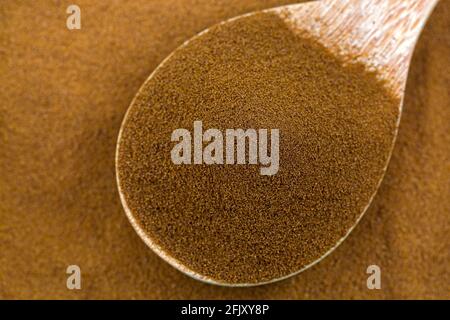 Reiner Instant-afrikanischer Spray getrockneter Kaffee aus Robusta- und Arabica-Kaffeebohnen in Holzlöffel, Draufsicht mit Nahaufbereitungsstruktur Stockfoto