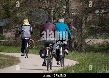 Drei Radfahrer in Winterkleidung genießen die Herbstsonne Die grüne Natur Stockfoto