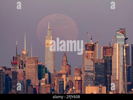 New York, USA. April 2021. Das Foto, das am 26. April 2021 in West Orange von New Jersey aufgenommen wurde, zeigt einen Supermond, der über der Skyline von Manhattan in New York, USA, aufsteigt. Quelle: Wang Ying/Xinhua/Alamy Live News Stockfoto