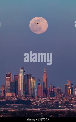 New York, USA. April 2021. Das Foto, das am 26. April 2021 in West Orange von New Jersey aufgenommen wurde, zeigt einen Supermond, der über der Skyline von Manhattan in New York, USA, aufsteigt. Quelle: Wang Ying/Xinhua/Alamy Live News Stockfoto