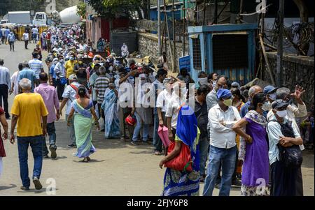 Mumbai, Indien. April 2021. In Goregaon, einem westlichen Vorort von Mumbai, Indien, stehen Menschen mit Gesichtsmasken in der Schlange, um sich impfen zu lassen, 26. April 2021. Quelle: Str/Xinhua/Alamy Live News Stockfoto
