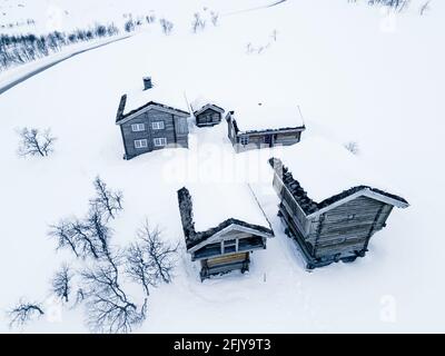 Klassische große klassische Holzhütte an einem schneereichen kalten Wintertag. Stockfoto