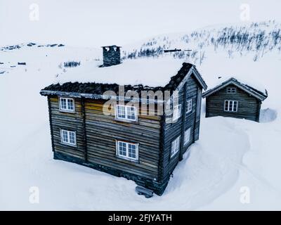 Klassische große klassische Holzhütte an einem schneereichen kalten Wintertag. Stockfoto